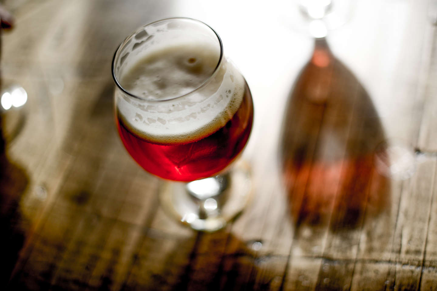 red-colored beer in stemmed glass